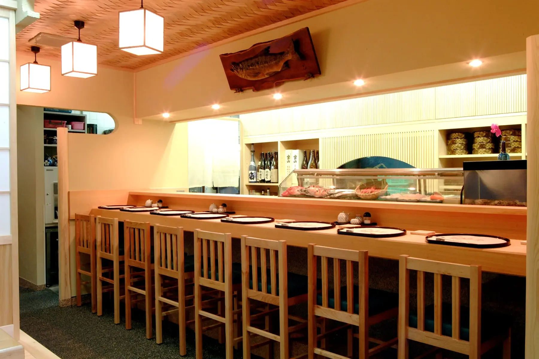 Pale-wood counter seating facing the fish case